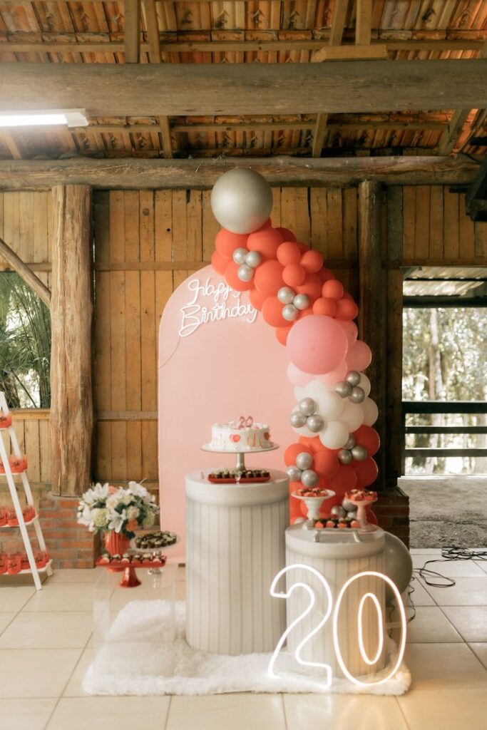 Elegant indoor decor for a 20th birthday party with balloons and birthday cake.