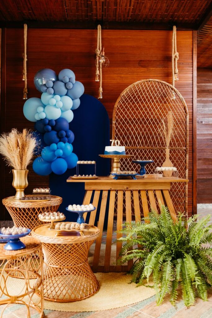 Sophisticated 70th birthday setup with blue balloons, cake, and rustic décor elements.